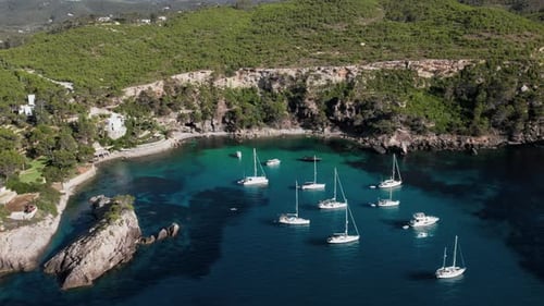 Yachts and sailing boats docked in beautiful cove on coast of island