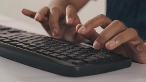 Mãos de homem digitando no teclado do computador