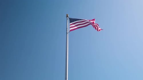 American Flag Waving Proudly Against Clear Blue Sky