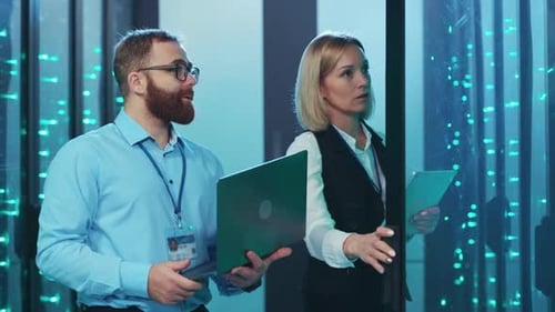 IT Colleagues Analyzing Data in a Bright Server Room