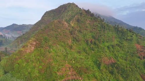 Ruhige Luftaufnahme einer grünen Bergkette und bewaldeter Hügel,