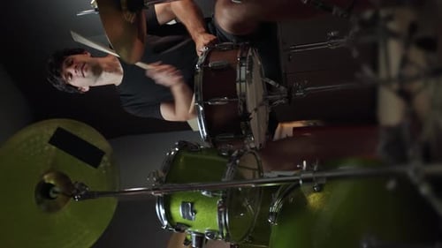 A Drummer is Playing the Snare Drum in a Recording Studio Holding Sticks in His Right Hand He is