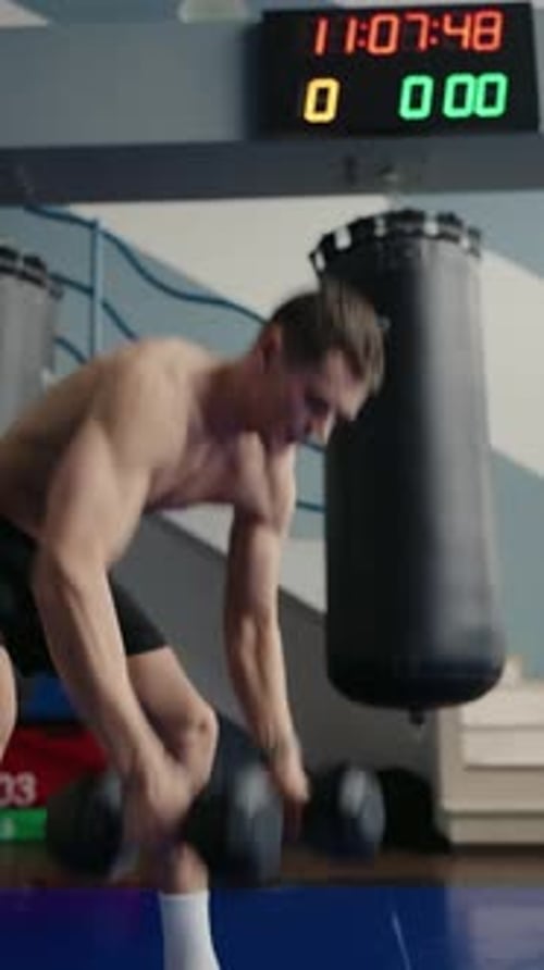 Fit Man Training with Dumbbells at Gym Intense Workout Session