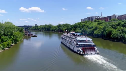 Ferry boat glides down river past nashville skyscrapers on a sunny afternoon