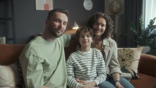 Happy Family Sitting on Couch Together at Home