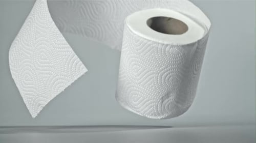 Roll of White Paper Towels Unrolling on Surface