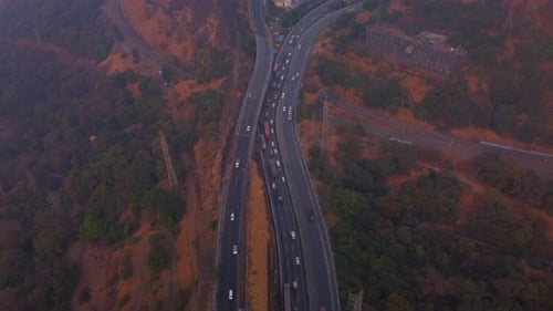 Multi lane Pune Mumbai Expressway carved through mountain valley, Lonavala city, Maharashtra, Drone