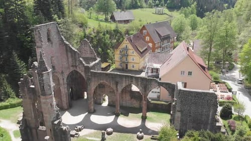 Allerheiligen Abbey ruins in picturesque village on sunny day. Aerial descending