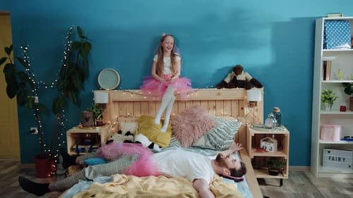 Father and Daughter Playing Dress Up on Bed