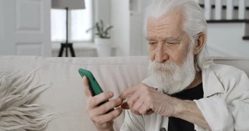 Crop View of Grey Haired Male Pensioner Scrolling and Looking at Phone Screen Old Bearded Man Using
