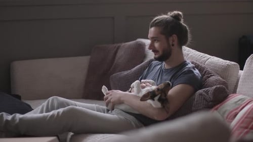 Man Relaxing on Couch with Small Dog