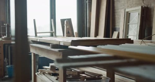 Softly Lit Wood Workshop with Door Being Built on Table with Saws
