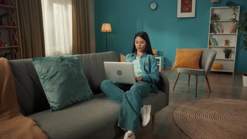 Young Adult Working on Laptop on Couch