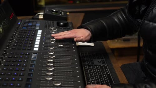 Music producer mixing audio track on digital console