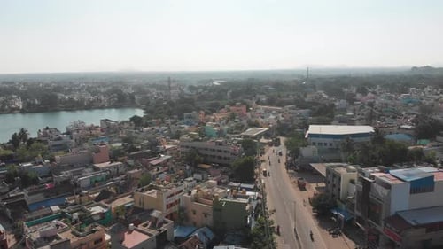 Aerial flight along main road in Tiruvannamalai City and natural pond in the middle of town.Beautifu