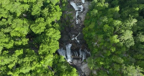 Whitewater Falls with Falling Down Clear Water From Rocky Boulders Between Green Lush Woods in