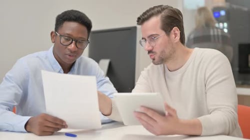Two Men Collaborating on Project Using Tablet