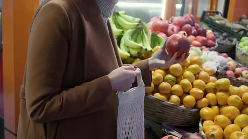 Young Woman Choosing Pomegranate at Fruit Vegetable Shelf in Grocery Store Healthy Food Nutrition