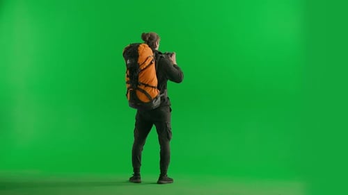 Back View of a Male Traveler Taking Photos on a Camera During a Hike A Male Traveler Stands Full