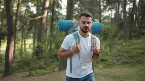 Shot of Young Man with Backpack Hiker Walking in the Forest Look Around at Sunlight Nature Alone