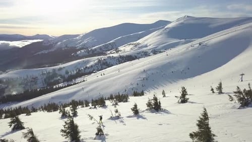 Aerial view of skiers navigating snow-covered peaks in winter landscape