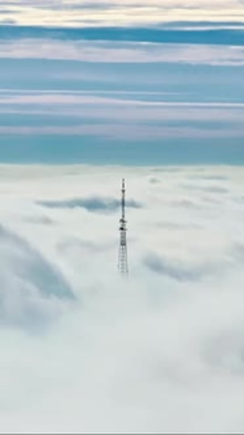 Aerial drone view of an utility pole in the clouds. Vertical