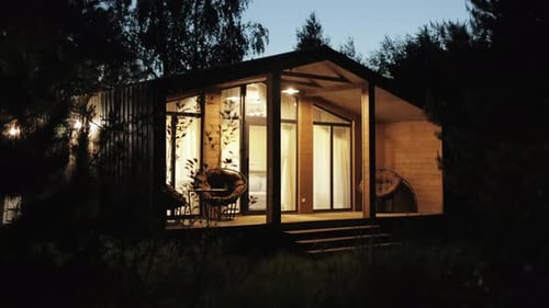 Illuminated Cabin in a Dark Forest at Night
