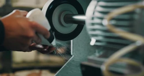 Close up of a shoemaker while he is sanding a silhouette of a shoe by using the italian tradition,