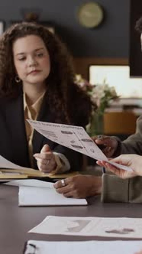 Business Meeting with Man and Woman Reviewing Documents
