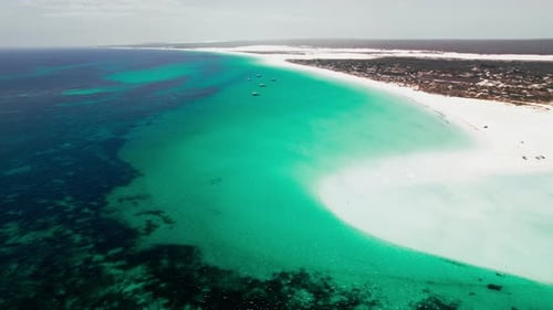 Aerial View of a Vast Turquoise Sea Meeting a Sandy Beach During Daytime