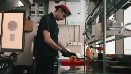 Professional Chef Slicing Bagel in Half in Restaurant Kitchen