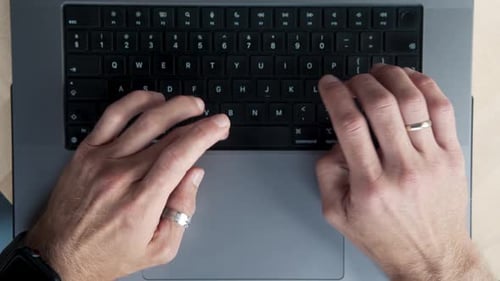 Hands of Office Man Typing on Keyboard of Laptop Computer and Writing Work Text