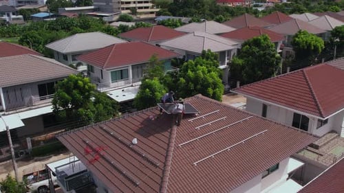 Drone view of engineer worker installed solar panels on roof of house.