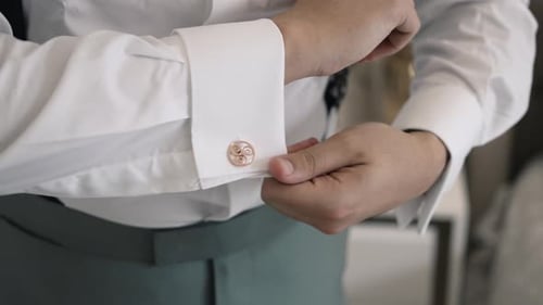 Man Fastens Elegant Cuff Links on Shirt