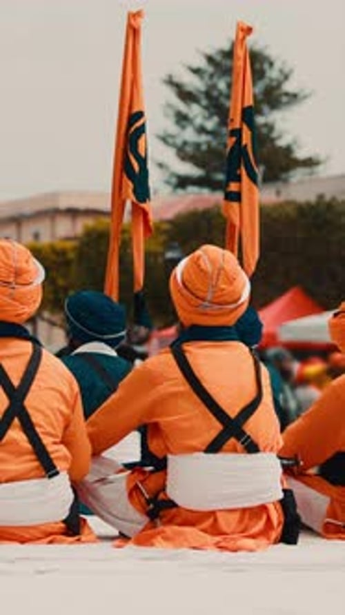 Des gardes indiens en uniforme orange avec un drapeau sikh lors du défilé culturel de Vaisakhi