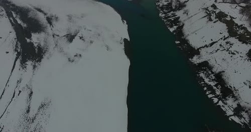 Aerial view of snow-covered river and mountains in winter, Pakistan.