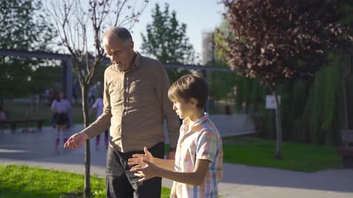 Grandfather and Child Walking and Talking in the Park