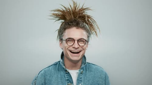 Young Man Laughing Happily Wearing Glasses and Denim