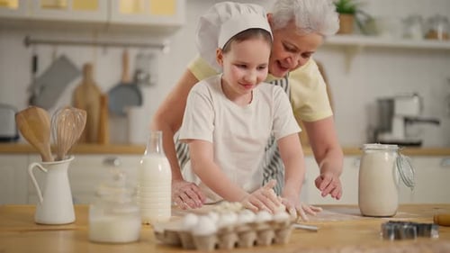 Child and Senior Baking Together in Kitchen