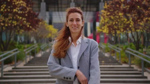 Uma mulher formal Corporativo atraente, confiante, feliz, sorridente, diversificada, em frente a um escritório