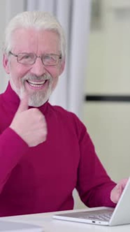 Senior Man Working on Laptop Gives Thumbs Up