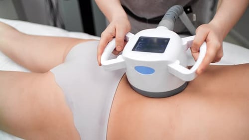 Modern Cavitation Procedure for Treating Cellulite and Excess Fat in Clinic Massaging Woman Body