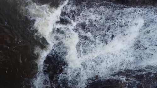 Lateral camera movement with drone filming the descent of a beautiful waterfall very close, flowing
