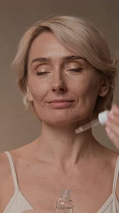 Woman Applying Facial Serum for Skincare Routine