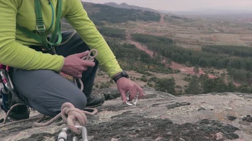 Alpinista prendendo uma corda em um mosquetão em uma rocha. Equipamento de escalada. Esporte extremo.