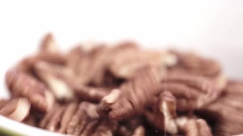 Pecans Falling into Bowl Close Up
