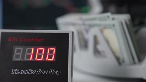 Red figures changing quickly on the screen of bill counter. Close up.