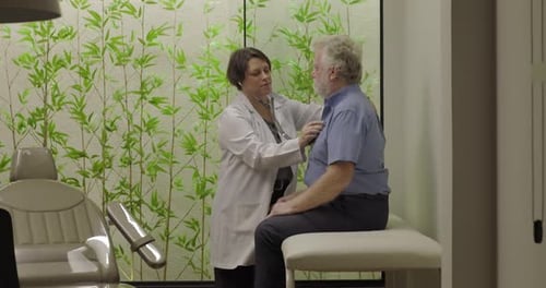 Doctor Listens to Senior Male Patient's Heart