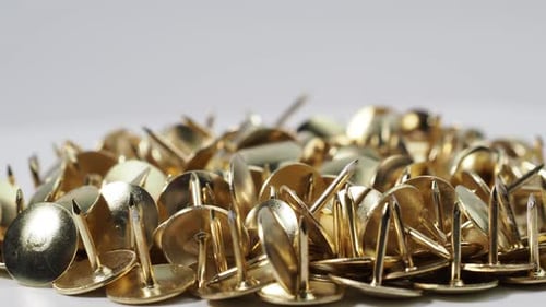 Pile of Golden Thumb Tacks Close Up