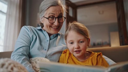 Grandmother and Granddaughter Reading a Book Together